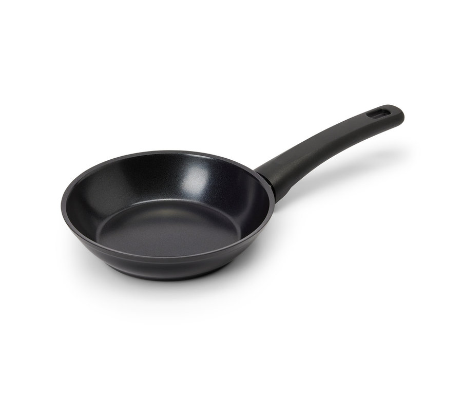 Eine schwarze Mini-Pfanne mit Antihaftbeschichtung und Griff liegt auf einer weißen Oberfläche.