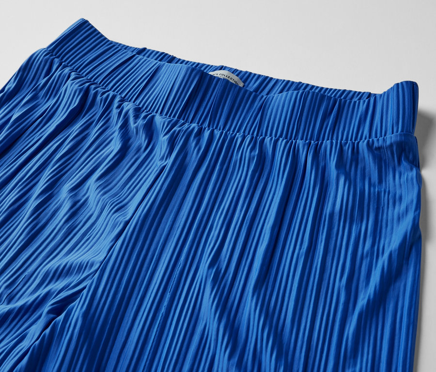 Detailaufnahme einer kobaltblauen Plisseehose.