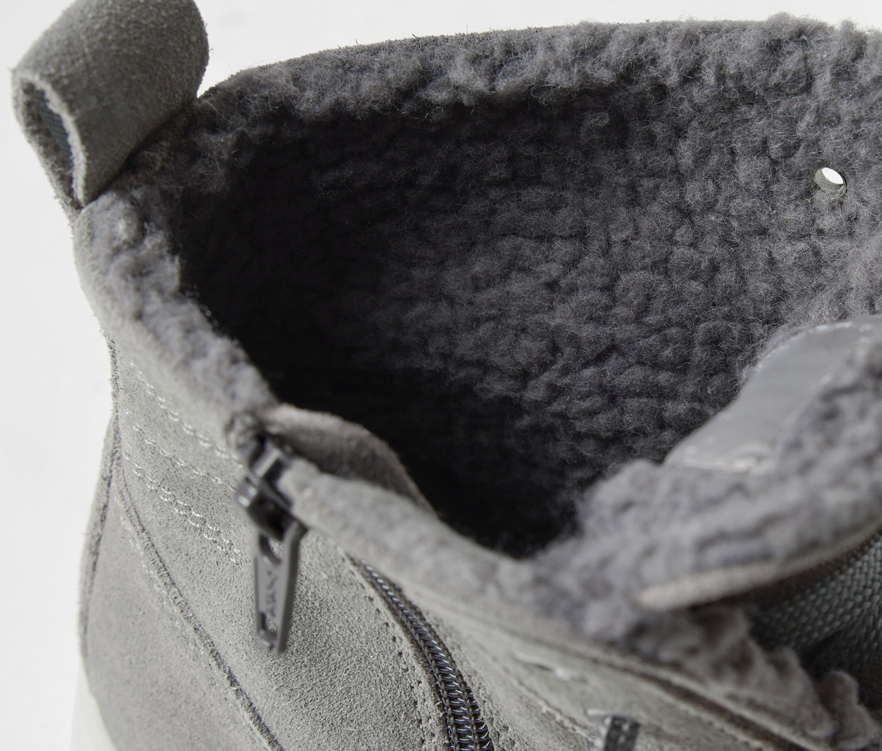 Detailaufnahme eines grauen Schnürstiefels mit Innenfell und Reißverschluss.
