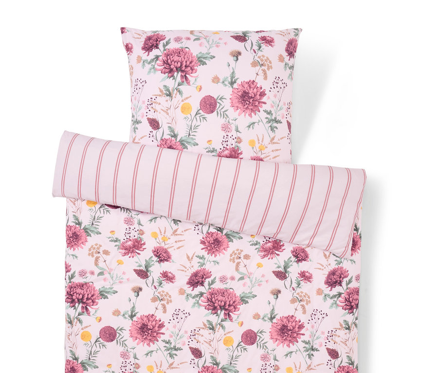 Bettwäsche mit Blumenmuster und gestreiftem Kissen.