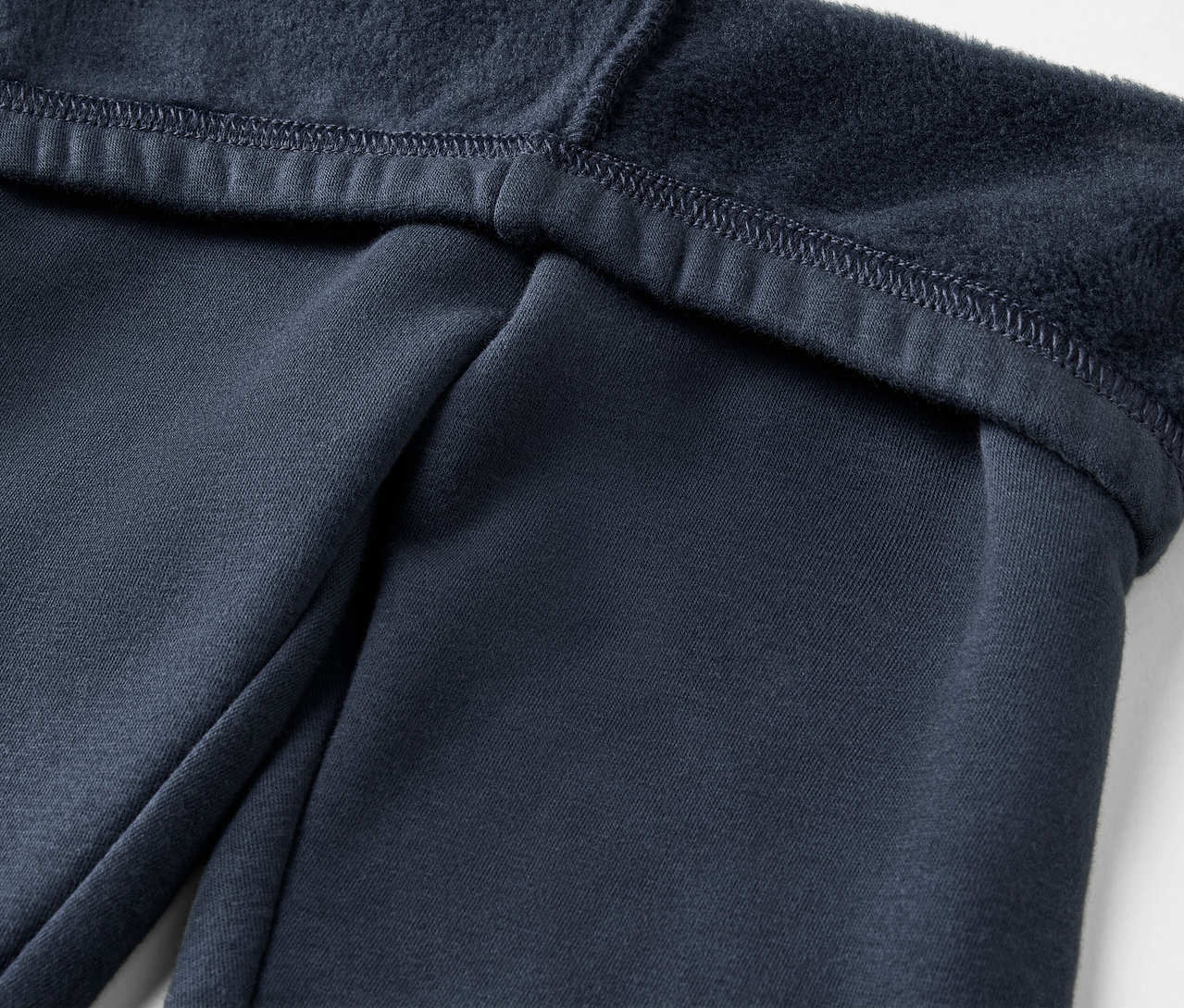Detailaufnahme einer marineblauen Trainingshose mit Fleecefutter.