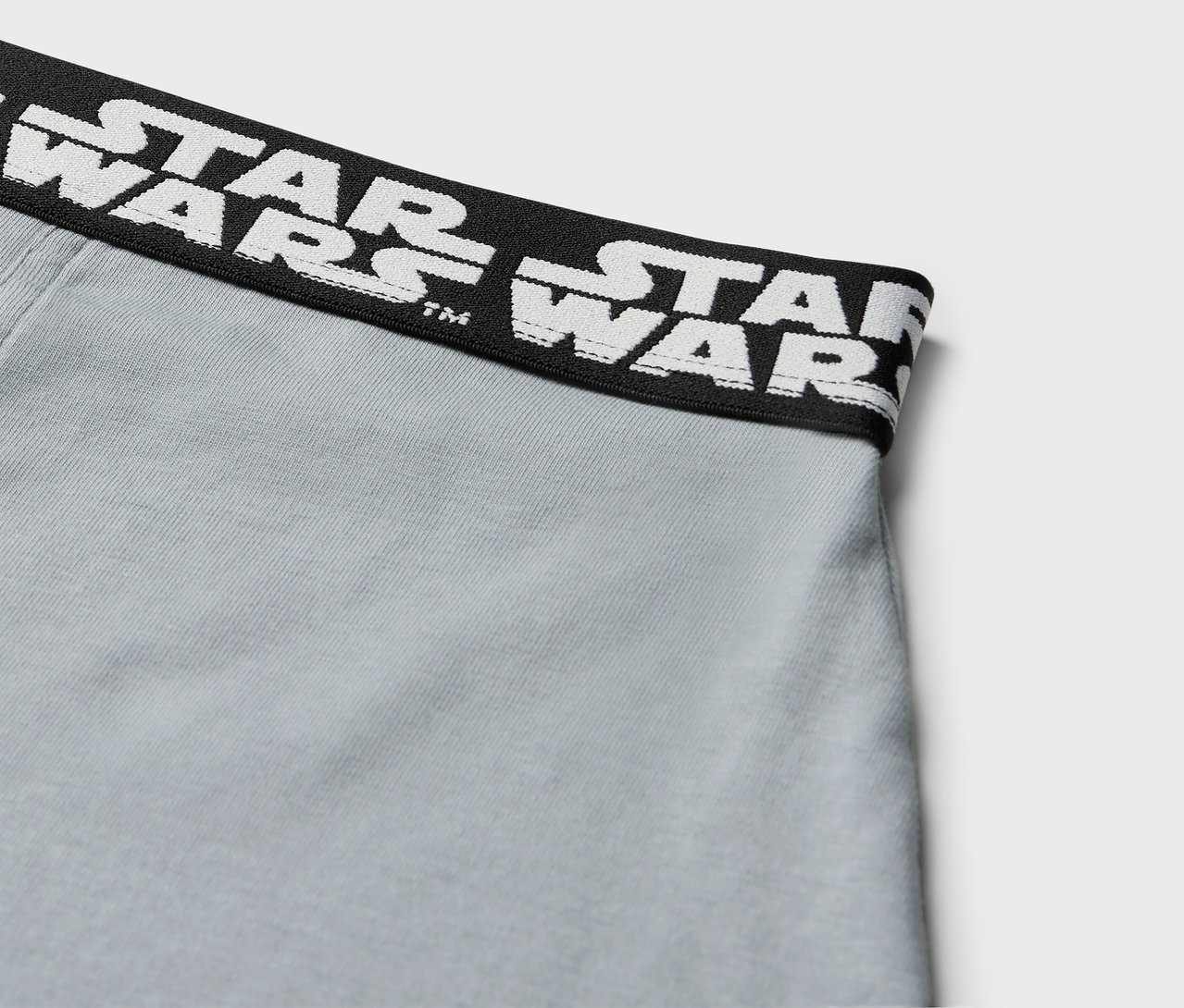 Detailaufnahme grauer Boxershorts mit schwarzem Bund mit weißem STAR WARS Schriftzug.
