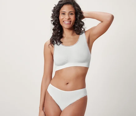 Frau posiert in weißem Seamless-Bustier.