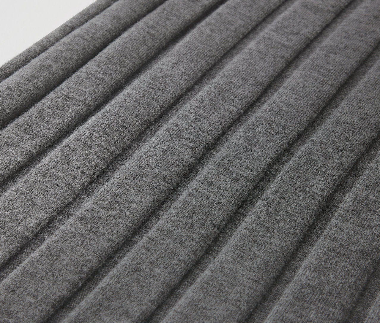 Detailaufnahme eines grauen Faltenstoffs.