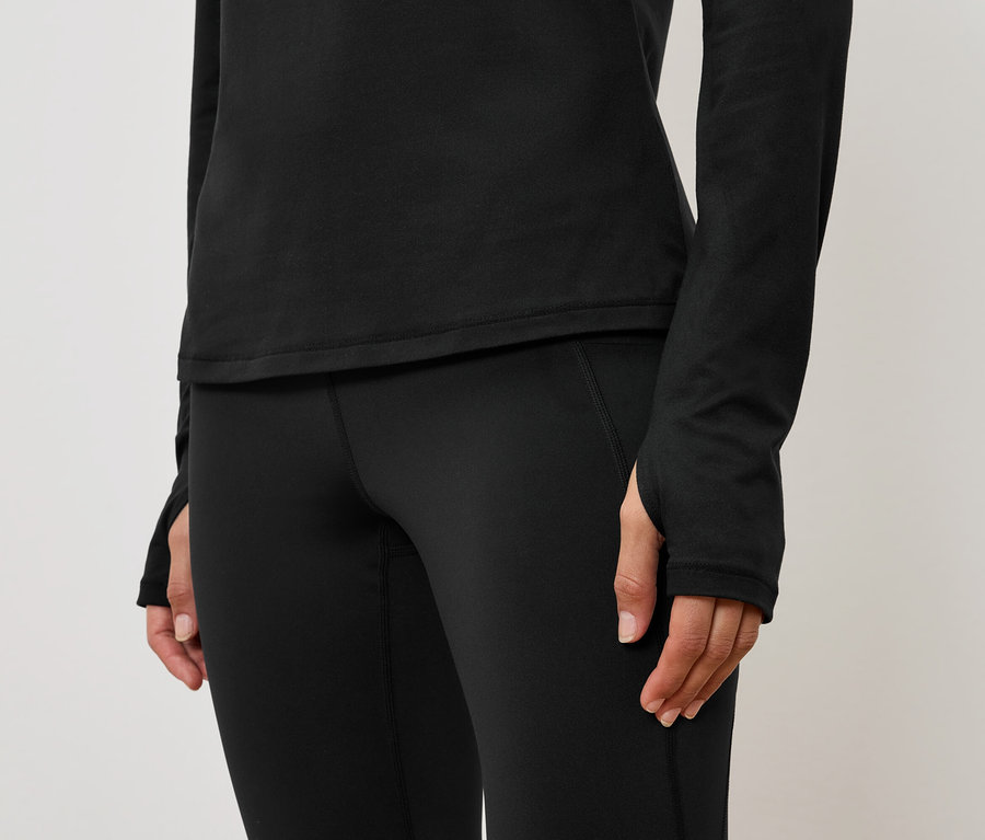 Detailaufnahme eines schwarzen Damen-Sportoutfits mit langärmligem Oberteil und Leggings.