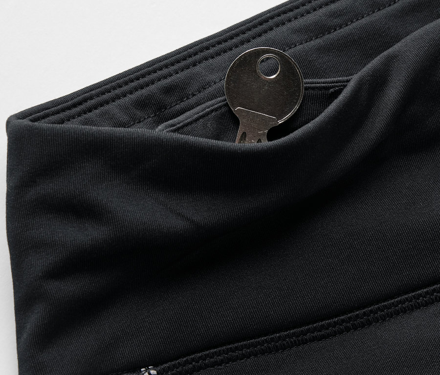 Detailaufnahme von schwarzen Leggings mit einem Schlüssel in der Tasche.