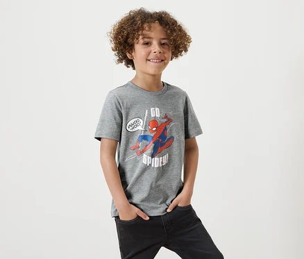 Ein Junge mit lockigem Haar trägt ein graues T-Shirt mit Spiderman-Aufdruck.