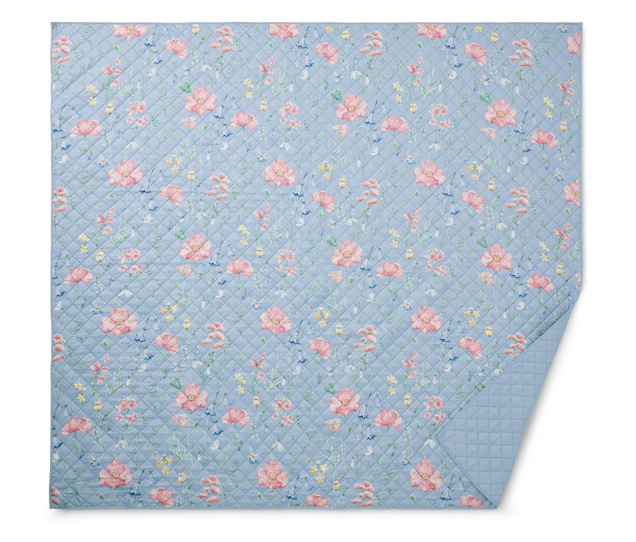 Hellblaue Steppdecke mit Blumenmuster.