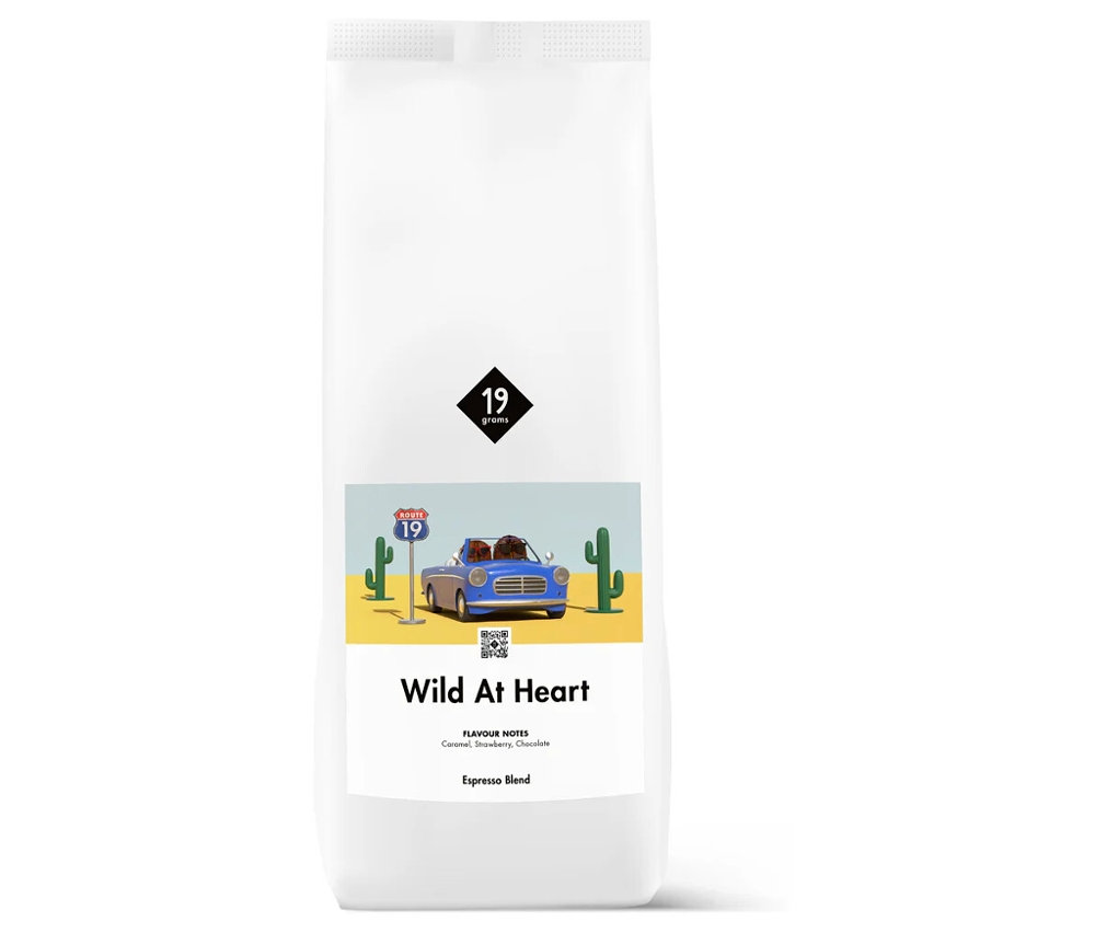 Weiße Packung 19grams – Wild at Heart Espresso - 1 kg Ganze Bohne mit einer Illustration eines blauen Autos in der Wüste.