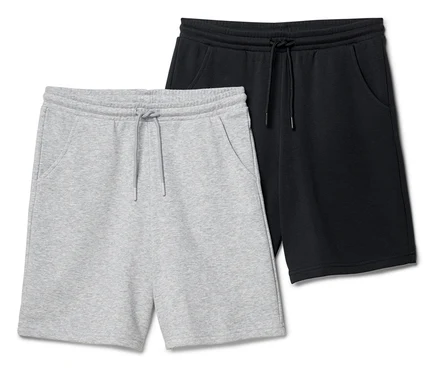 Zwei kurze Hosen, eine hellgraue und eine schwarze, liegen nebeneinander.
