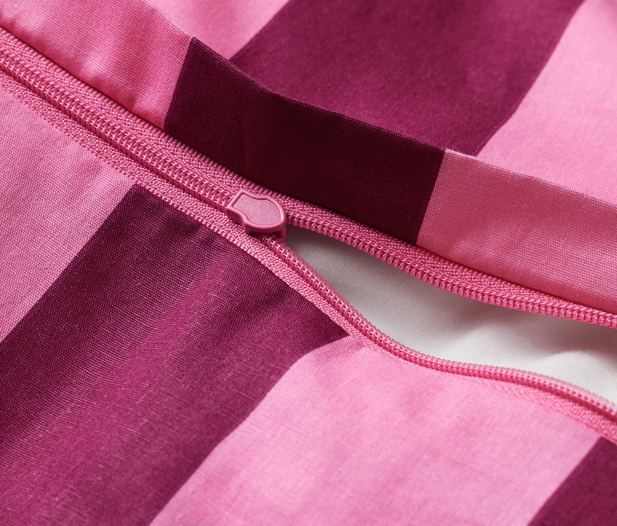 Nahaufnahme eines rosafarbenen Bettbezugs mit Reißverschluss.
