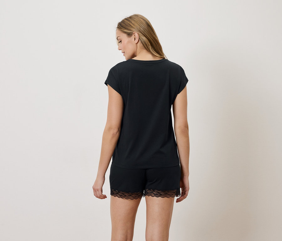 Frau von hinten in schwarzem T-Shirt und Shorts mit Spitzendetails.