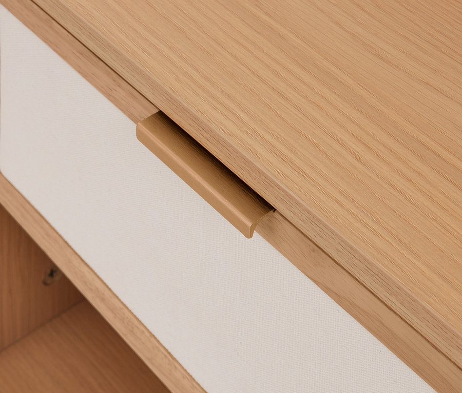 Helle Holzschublade mit cremefarbenem Stoffbezug und integriertem Holzgriff.