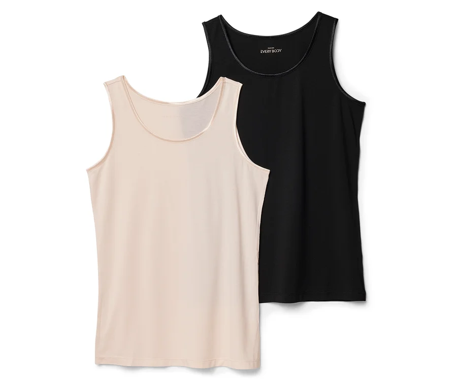 Zwei Tanktops, eines beige und eines schwarz, liegen flach. Das beige ist im Vordergrund, das schwarze leicht dahinter.