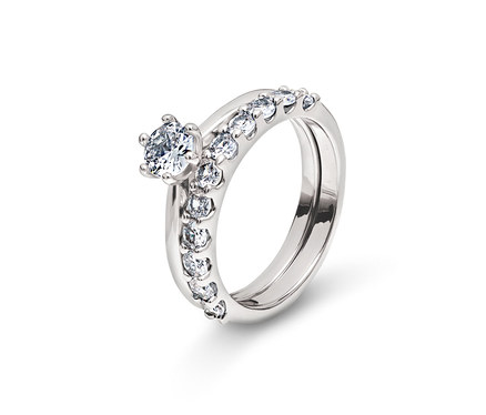 Zwei silberne Ringe mit klaren Steinen auf weißem Hintergrund.