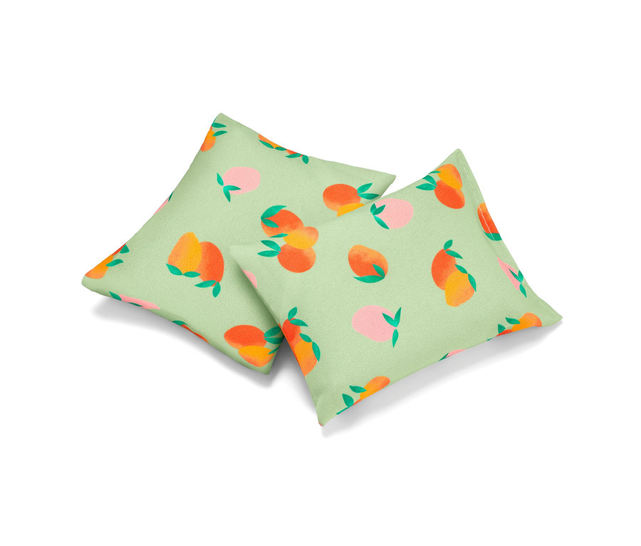 Zwei Erfrischungskissen mit Pfirsichmuster auf hellgrünem Hintergrund.