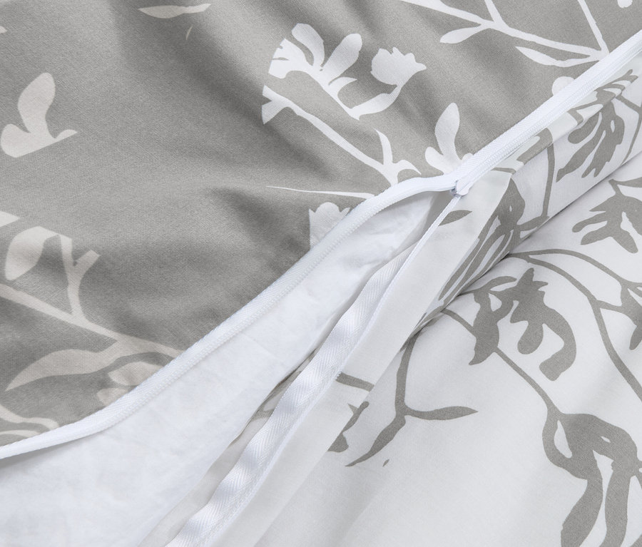 Detailaufnahme von grauer Renforcé-Bettwäsche mit Blumenmuster und Reißverschluss.