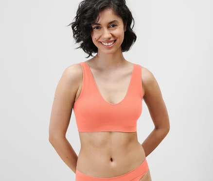 Lächelnde Frau trägt ein Seamless-Bustier in Papaya.