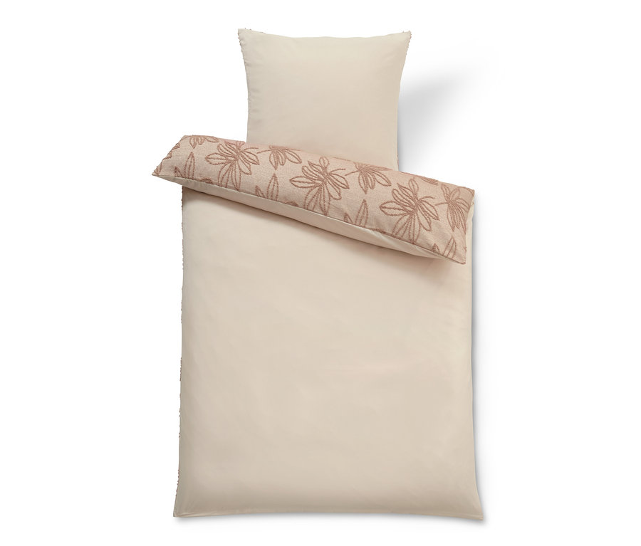 Beige Bettwäsche mit getufteter Verzierung.