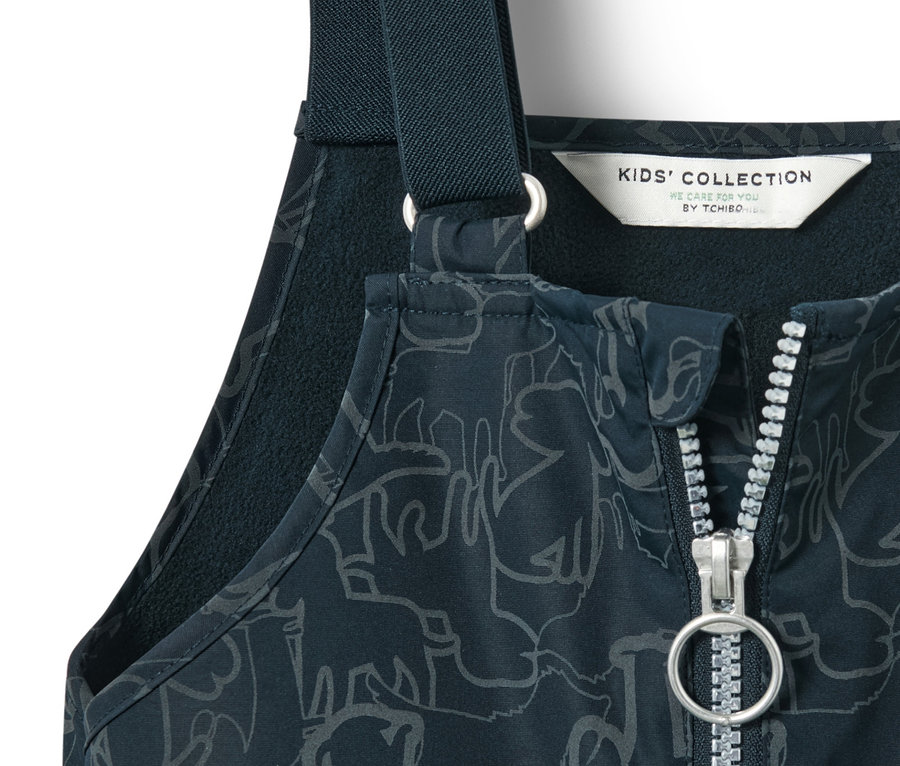 Detailaufnahme einer dunkelblauen Kinder Thermo-Regenhose mit reflektierenden Elementen, Reißverschluss und Tiermuster.