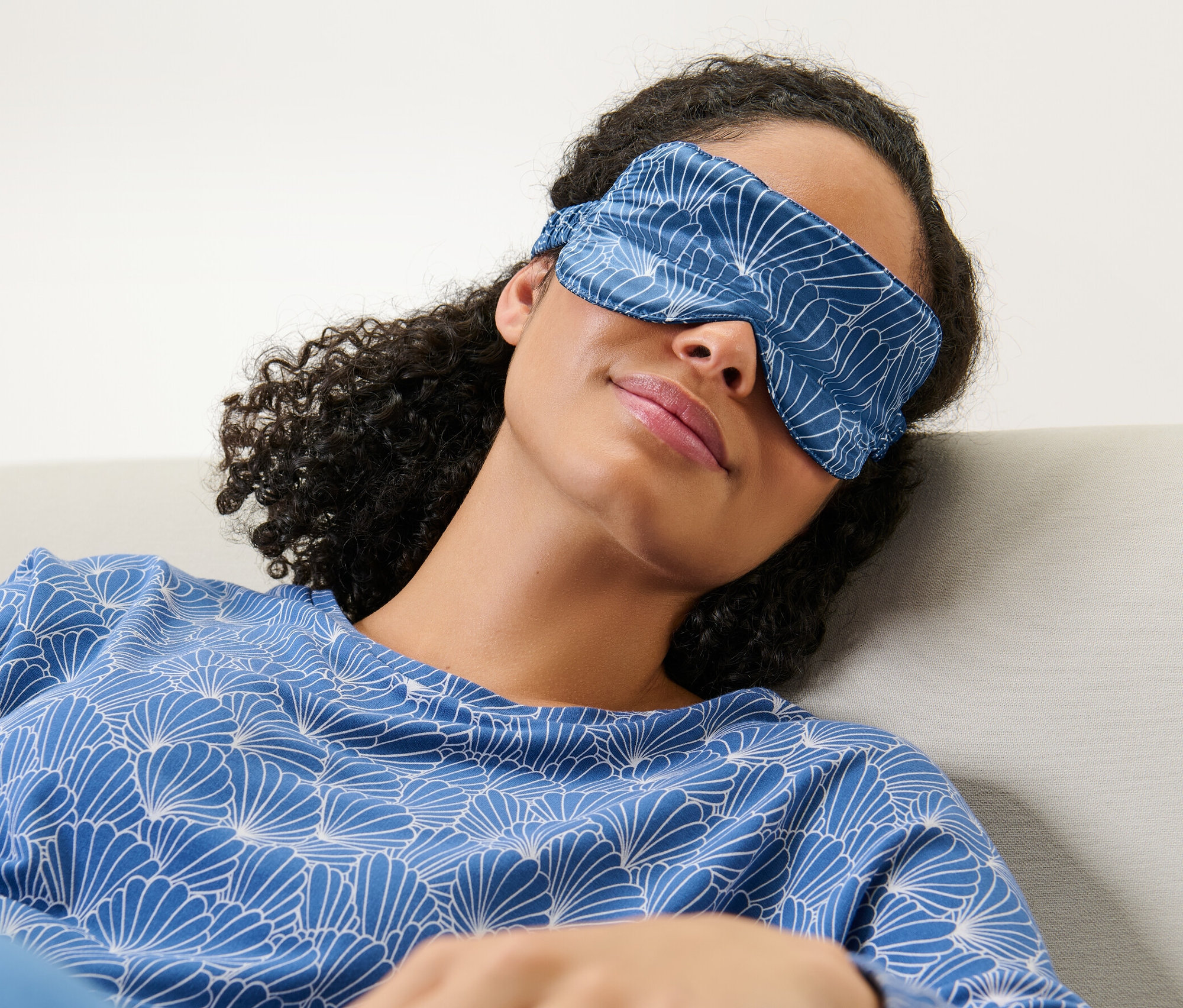 Frau liegt mit einer Seiden-Schlafmaske auf den Augen.