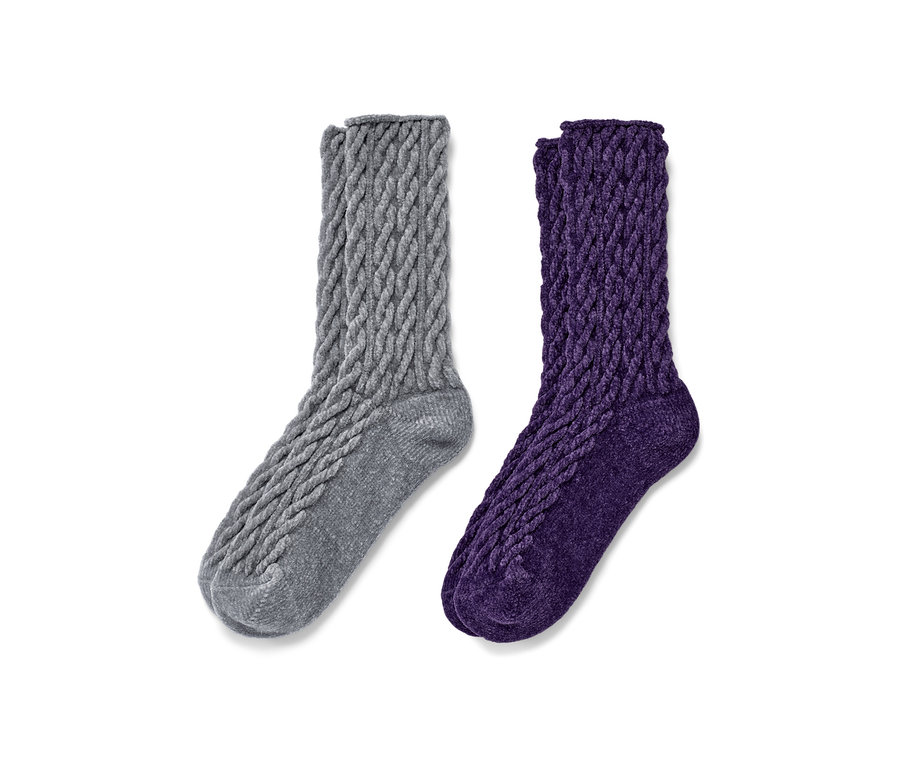 Zwei Paar flauschige Socken mit Zopfmuster, ein Paar grau, ein Paar lila.