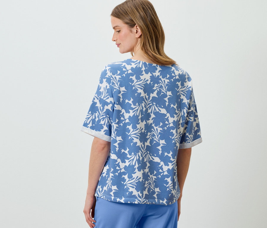 Frau trägt ein hellblaues bedrucktes Sweatshirt.