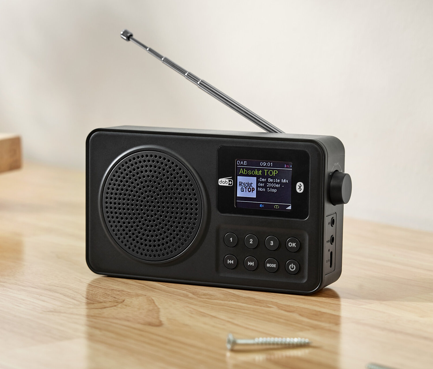 Schwarzes DAB+/ FM-Radio auf einem Holztisch mit Werkzeugen.