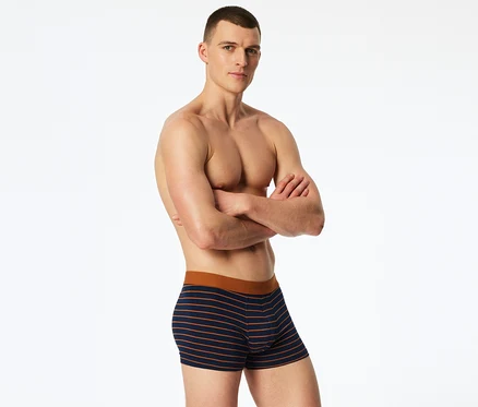 Ein oberkörperfreier Mann mit verschränkten Armen trägt gestreifte SCHIESSER Slipboxer.