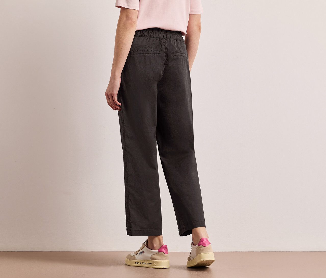 Frau von hinten mit Street One Papertouch-Hose in Schwarz und Sneakern.