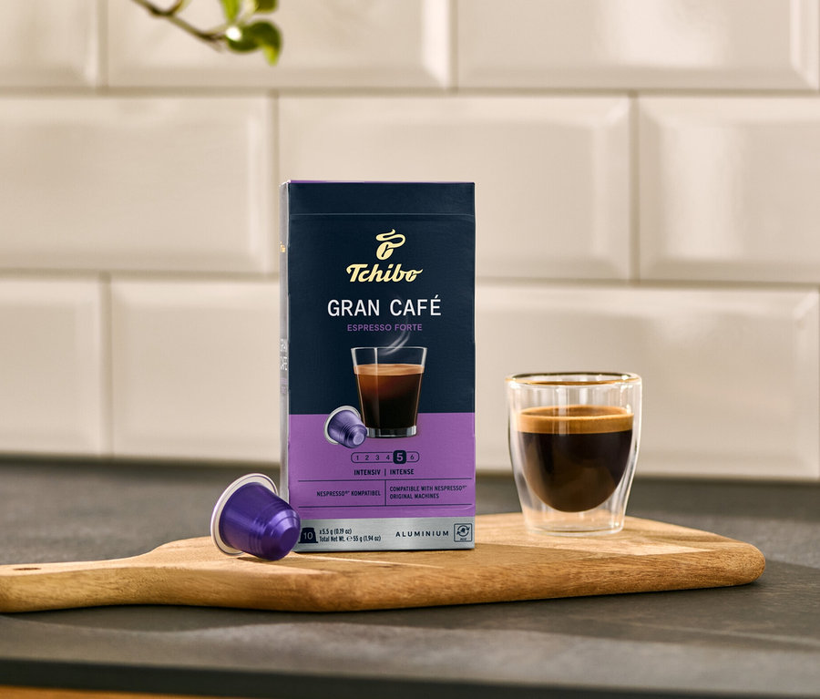 Eine Packung Gran Café Espresso Forte - 10 Kapseln neben einer Tasse Espresso auf einem Brett.