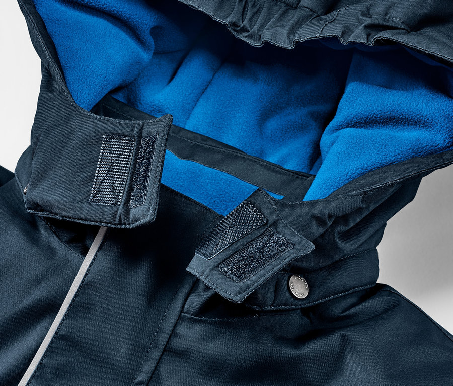 Detailansicht einer Kinder-Skijacke mit Kapuze und blauem Fleecefutter.