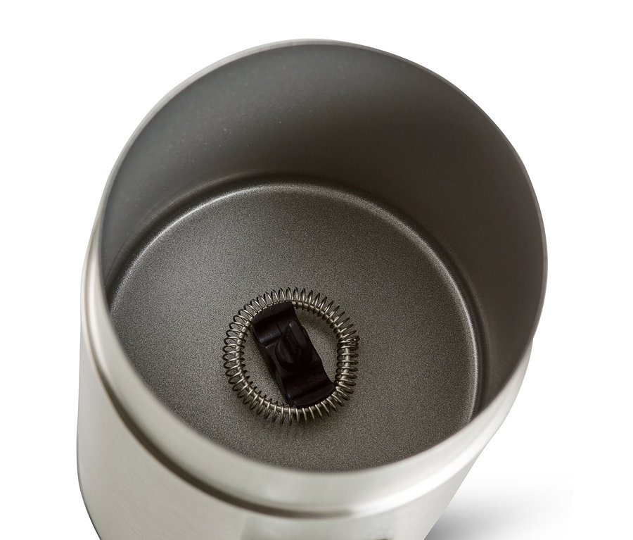 Draufsicht in einen elektrischen Milchaufschäumer aus Edelstahl mit Schneebesen im Inneren.