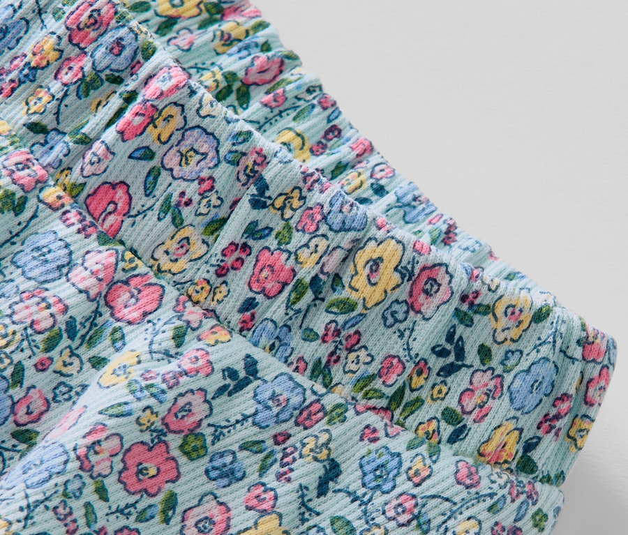 Detailansicht eines Kinder-Rocks mit Hose mit Blumenmuster.