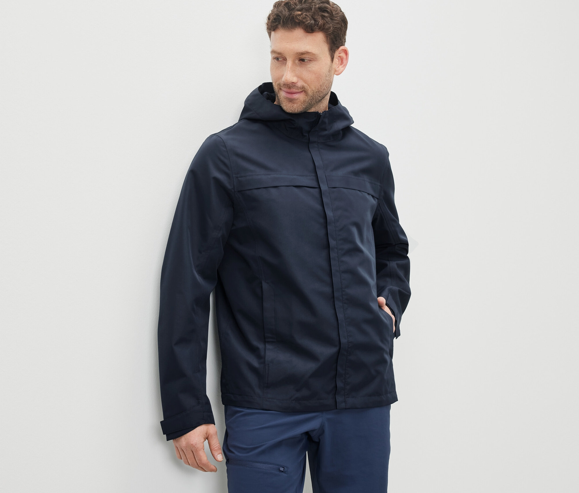 Mann trägt einen dunkelblauen Funktionsparka.