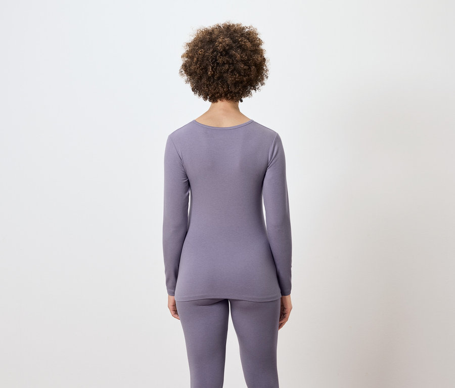 Rückansicht einer Frau mit Afro-Frisur in lila Thermounterwäsche.