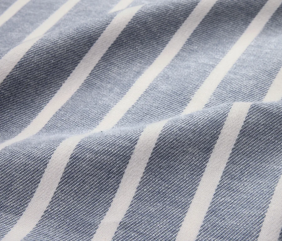 Nahaufnahme von blau-gestreifter Flanell-Bettwäsche in Übergröße.