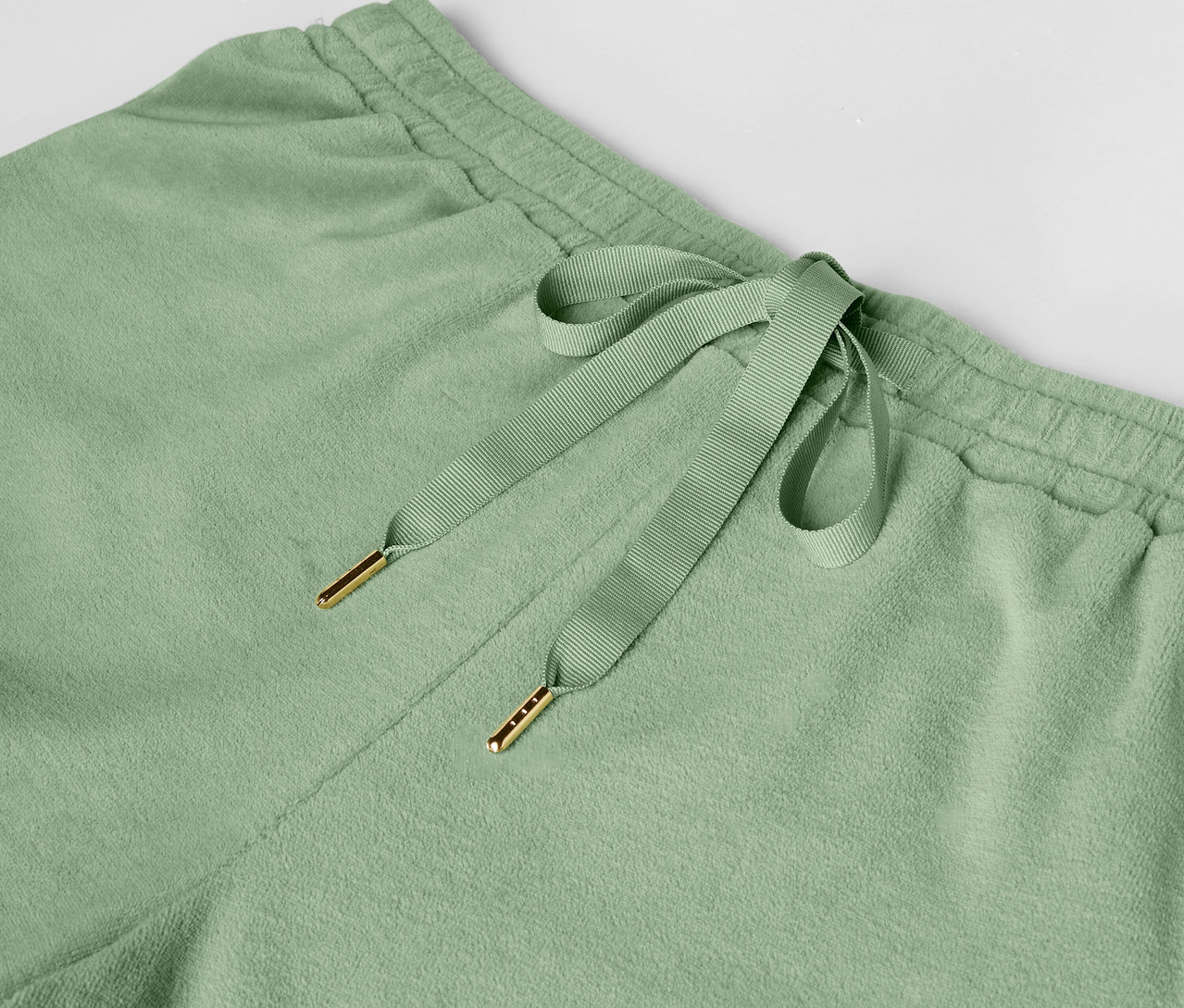 Detailaufnahme einer hellgrünen Jogginghose mit Kordelzug.