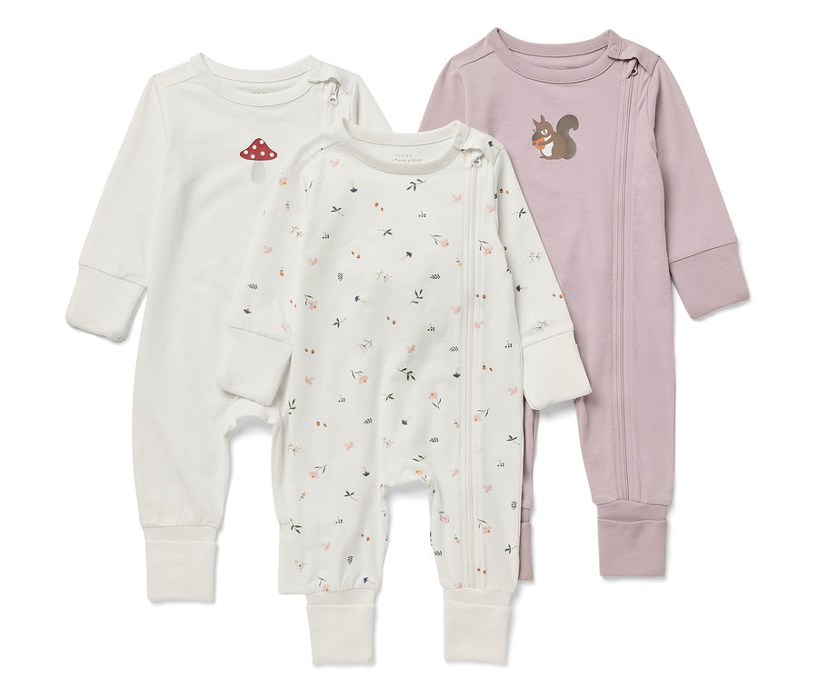 Drei Baby-Overalls mit langen Ärmeln. Einer ist weiß mit einem Fliegenpilz, einer mit einem Blumenmuster und einer ist lila mit einem Eichhörnchen.