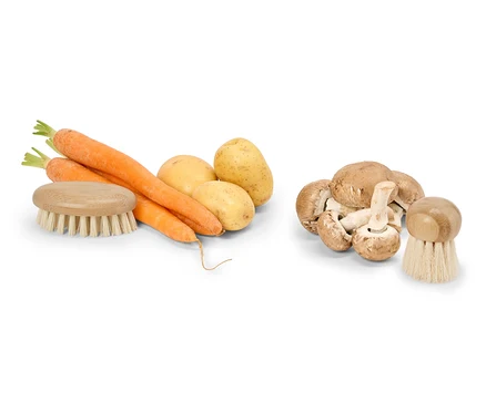 Ein Haufen Karotten, Kartoffeln und Champignons mit einer Gemüsebürste.