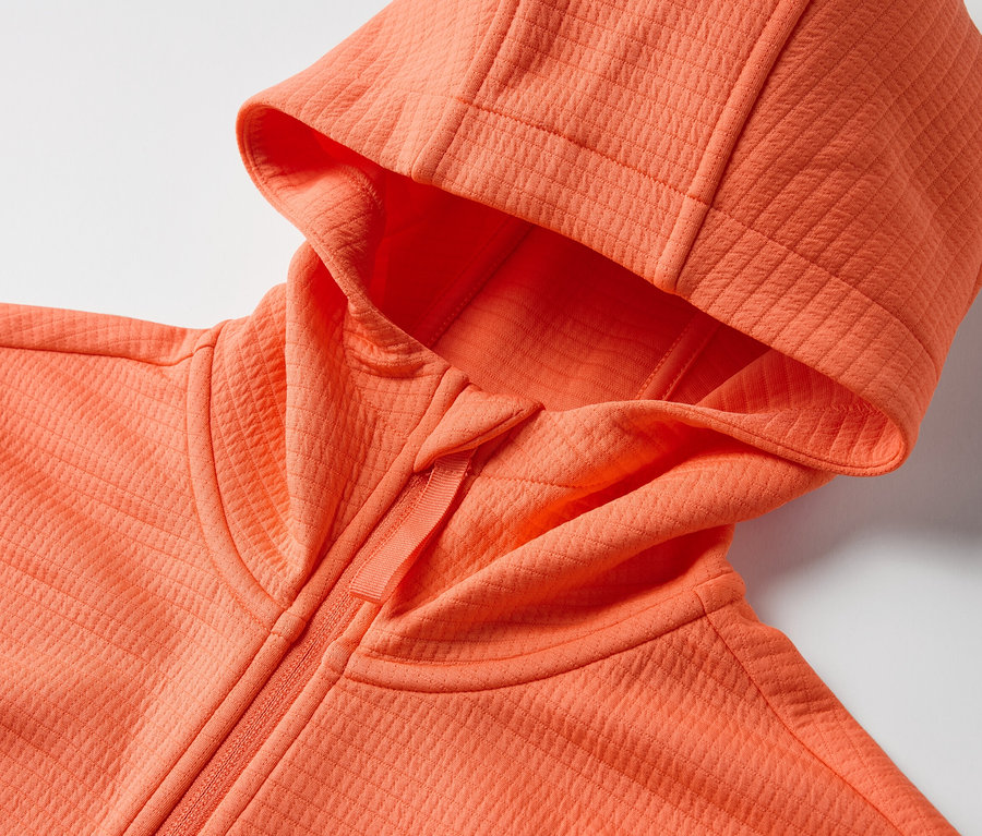 Detailansicht einer orangefarbenen Funktionsjacke mit Kapuze.