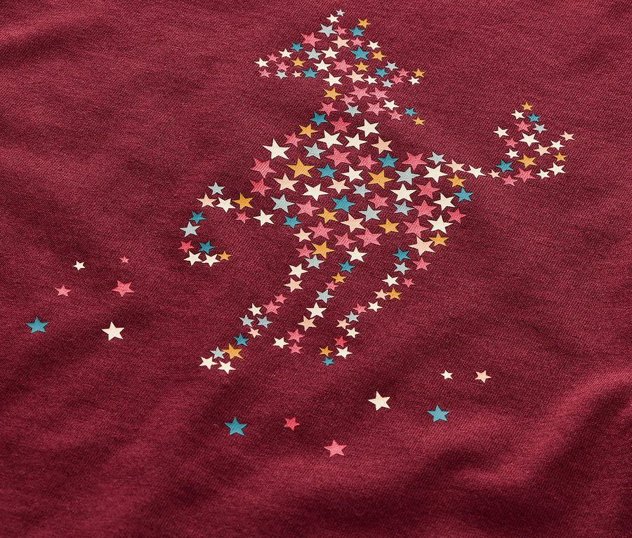 Detailaufnahme eines Kinderpyjamas mit einem Pferdemotiv aus Sternen.