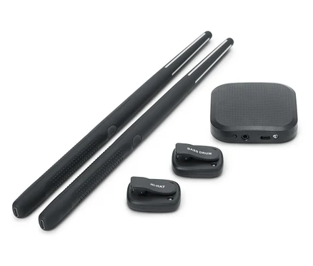 Zwei schwarze Drumsticks liegen nebeneinander. Eine schwarze Soundbox und zwei kleine schwarze Drum-Pads, eines mit der Aufschrift BASS DRUM und eines mit der Aufschrift HI-HAT, sind ebenfalls vorhanden.