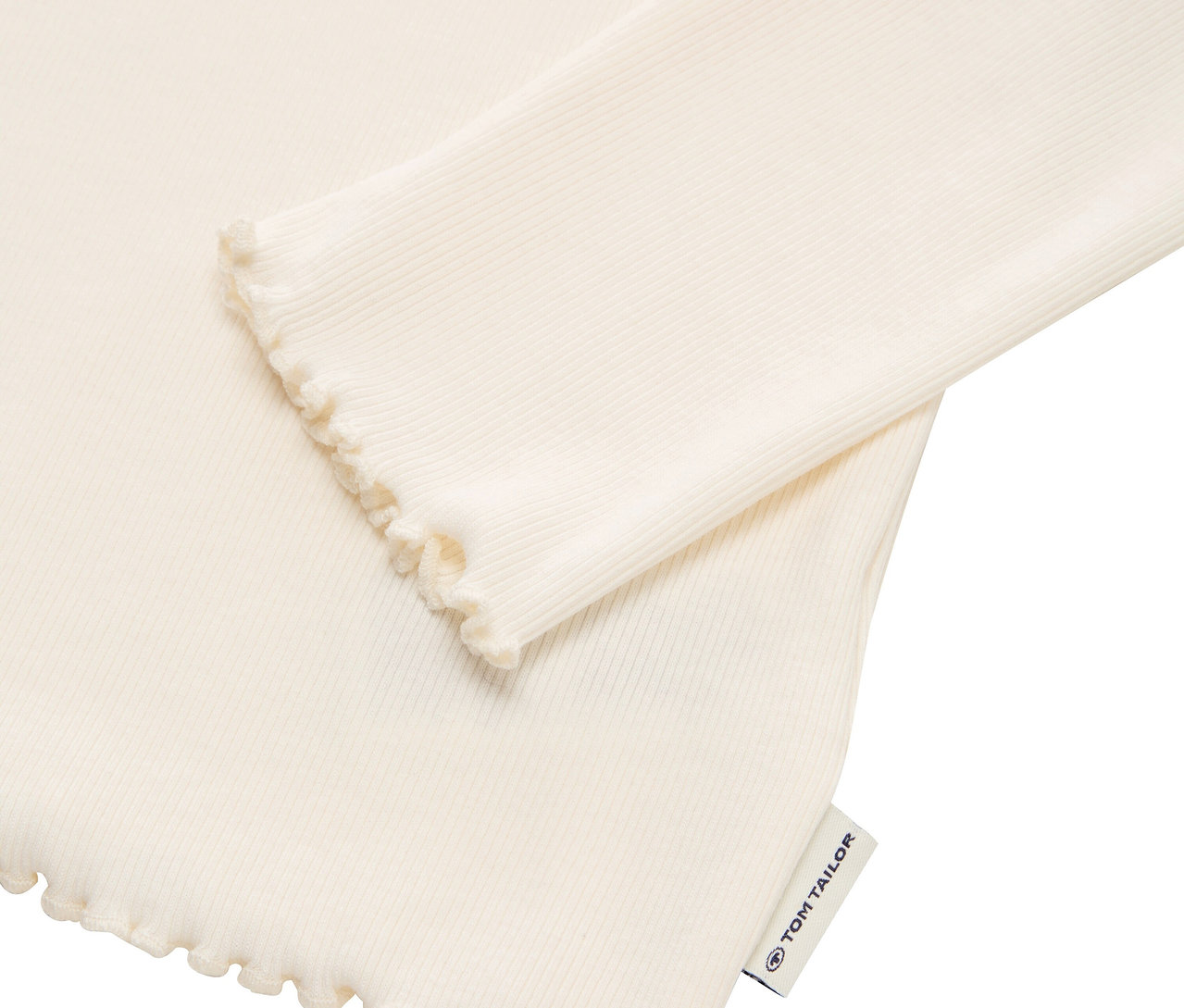Detail eines cremefarbenen, gerippten Langarmshirts mit Rüschenkante und Tom Tailor Etikett.