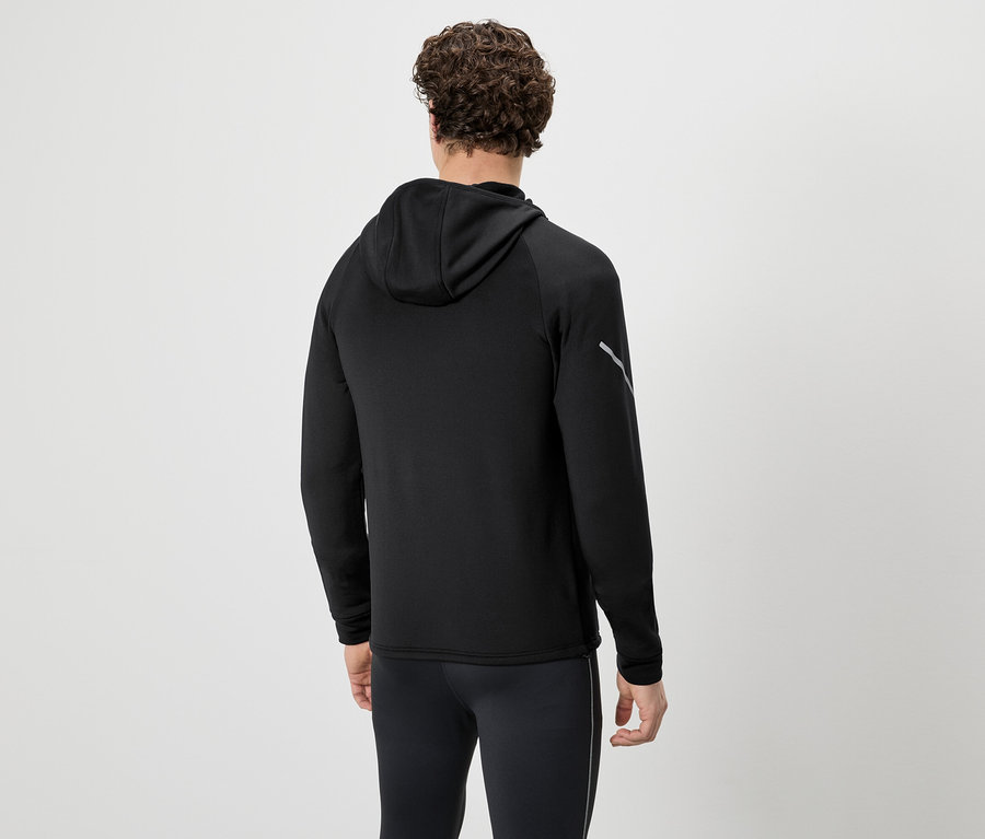 Mann von hinten in schwarzem Trainingsanzug mit Kapuzenpullover und Hose vor neutralem Hintergrund.