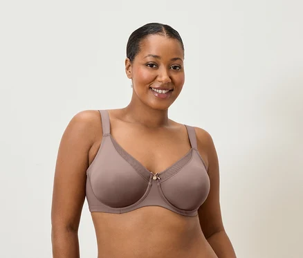Frau lächelt und trägt einen BH in Mauve.