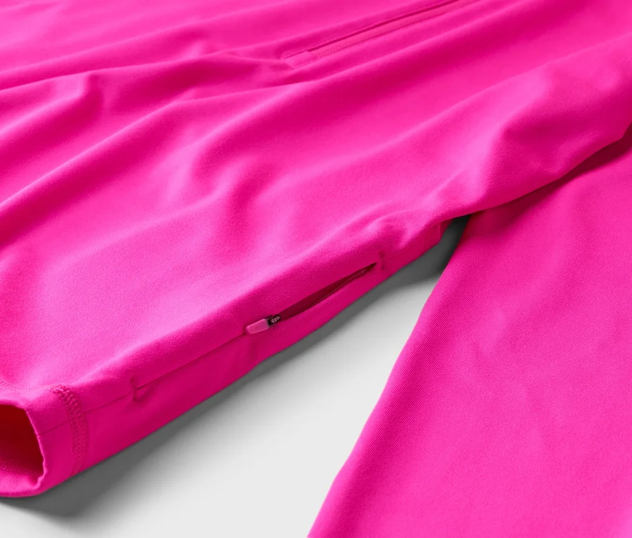 Nahaufnahme einer pinken Jacke mit Reißverschlusstasche am Ärmel.