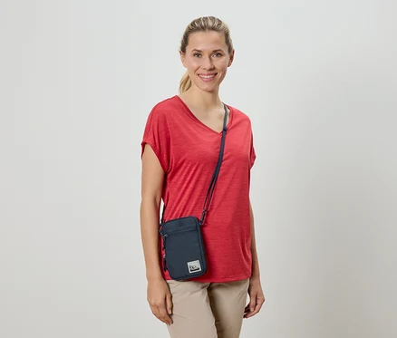 Frau mit rotem T-Shirt und Umhängetasche.