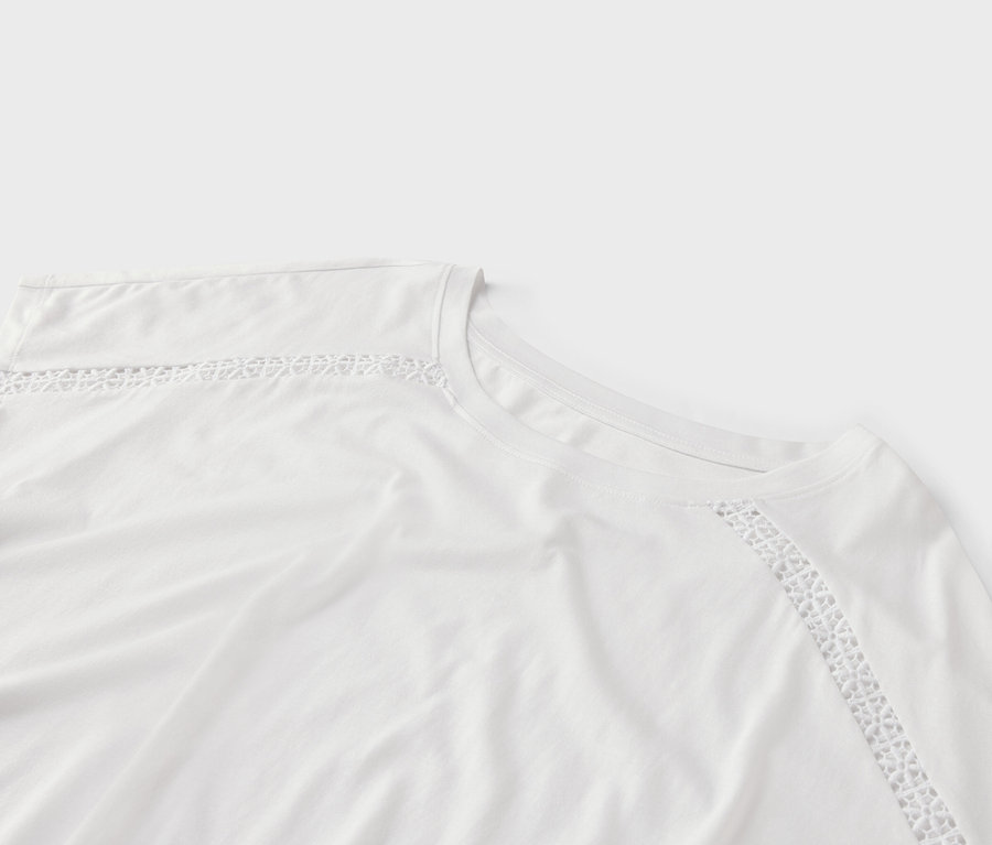 Nahaufnahme eines weißen T-Shirts mit Spitzenbesatz am Kragen und an der Schulter.