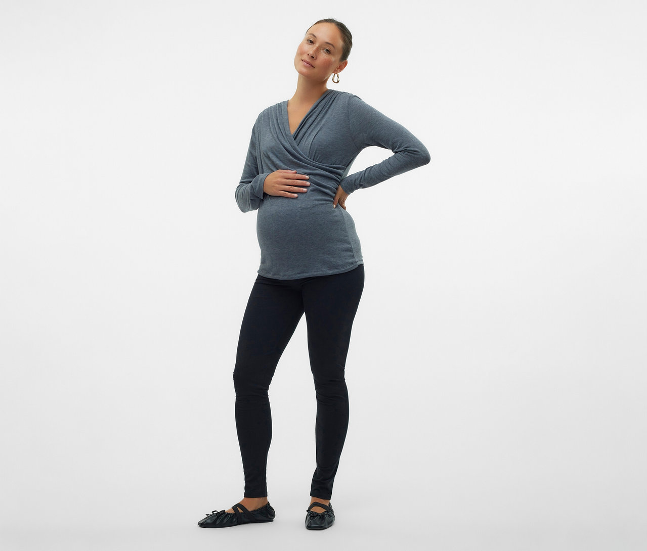 Schwangere trägt MAMALICIOUS 2er Pack Leggins »MLEMMA« mit grauem Oberteil. Sie hält eine Hand auf dem Bauch und die andere in der Hüfte.